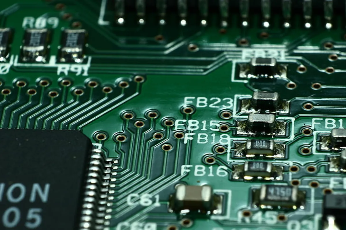 Close-up macro of a printed circuit board print plate, showing copper traces and plated vias.